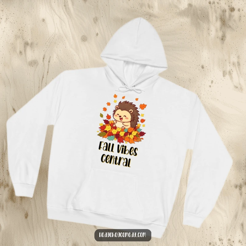 Warm funny hoodie featuring a happy hedgehog completely immersed and rolling excitedly in a pile of colorful fall leaves.